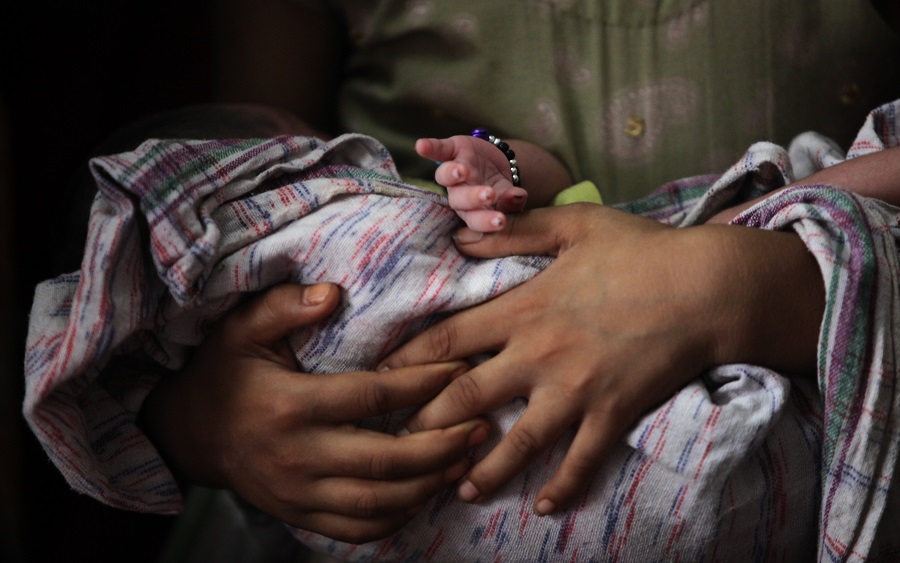 A mother holds her baby before vaccination