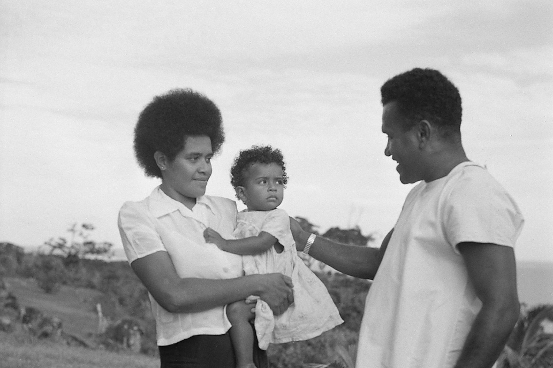WHO_A_014544_crop and 1920px Taione Sikivou (right), leader of the Kadavu Island Yaws Team examining babies for yaws in the village of Namara in 1955.